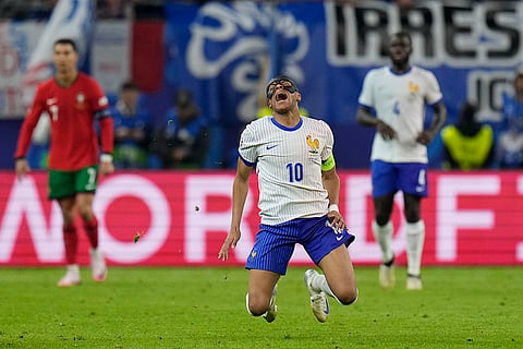 Kylian Mbappe falls after a collision with Joao Palhinha 
